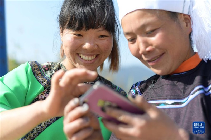 在貴州省黔東南苗族侗族自治州榕江縣水尾水族鄉(xiāng)拉術(shù)村，一位村民（右）在學(xué)習(xí)使用手機(jī)（2020年10月24日攝）。新華社記者 楊楹 攝