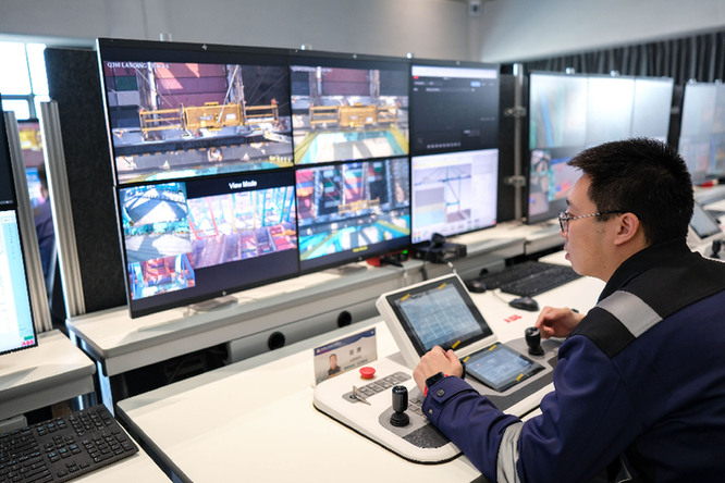 在天津港全物聯(lián)網(wǎng)集裝箱碼頭智控中心，工作人員遠(yuǎn)程操控碼頭機(jī)械設(shè)備。新華社記者　張鋮　攝