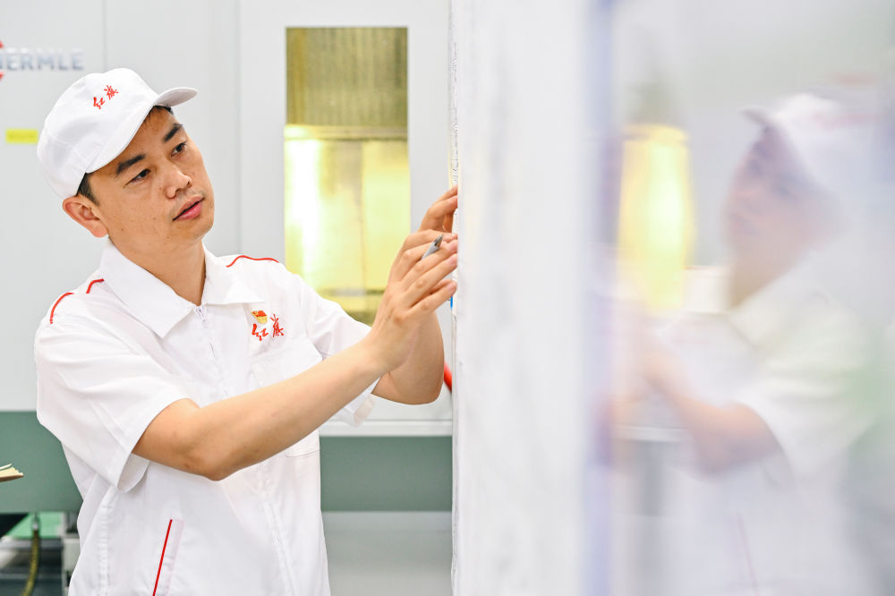 2023年6月8日，一汽研發(fā)總院首席技能大師楊永修查看發(fā)動(dòng)機(jī)圖紙細(xì)節(jié)。新華社記者 許暢 攝