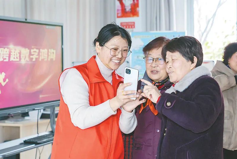 我國(guó)持續(xù)加快信息化服務(wù)普及，縮小數(shù)字鴻溝，讓更多人共享互聯(lián)網(wǎng)發(fā)展成果。圖為3月18日，江蘇省南通市海安高新區(qū)志愿者在隆政街道林橋村農(nóng)家書屋手把手指導(dǎo)老年人使用智能手機(jī)應(yīng)用。