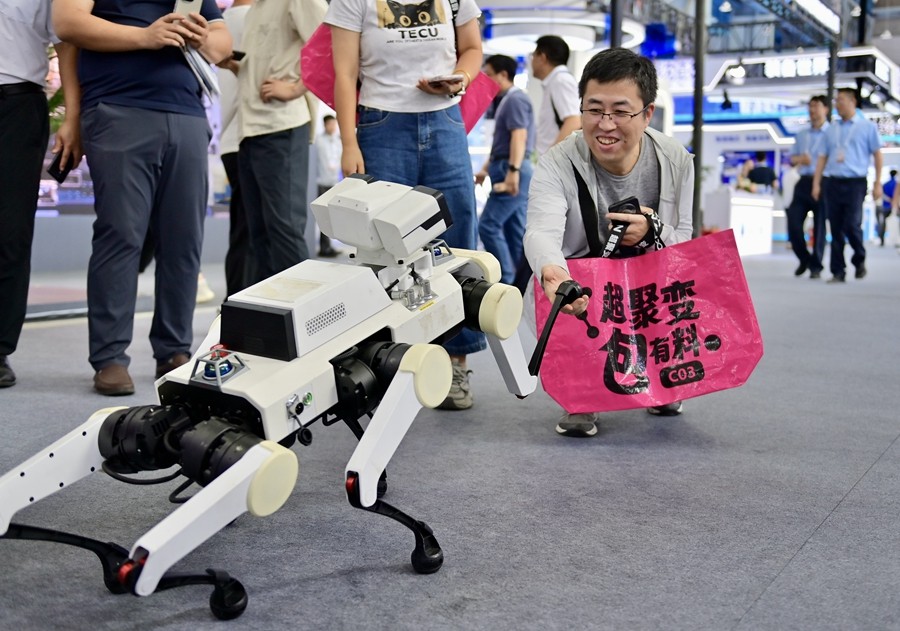 9月6日在2025全球工業(yè)互聯(lián)網(wǎng)大會(huì)展覽區(qū)，一名參觀者與聯(lián)想足式機(jī)器人互動(dòng)。新華社記者 吳青昊 攝