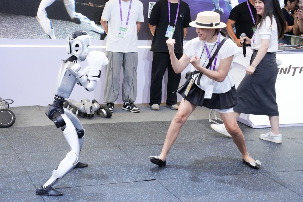 2025年9月19日，在第22屆中國—東盟博覽會(huì)上的人工智能專館里，一臺(tái)人形機(jī)器人表演“拳擊”，與觀眾互動(dòng)。新華社記者 周汀鷺 攝